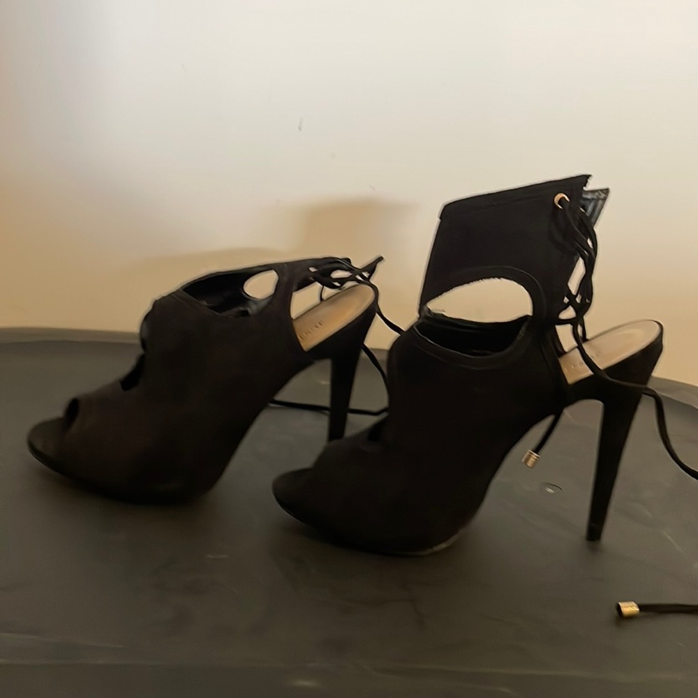 Black high heel sandals with back ties in the back and open toe.